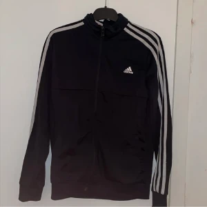 Adidas kofta - Säljer denna igen men för ett lägre pris då den bara hänger i garderoben❤️ finns inga fel på koftan utan det är bara dom vita sträcken som har blivit gråa men sysn bsra med flash❤️