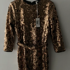 Paljett klänning guld oanvänd Nelly - Oanvänd paljettklänning från Nelly i guld. Storlek 36. 