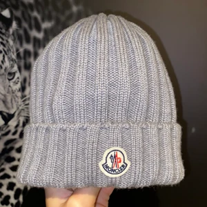 Moncler Mössa - Skick 9/10 (använd januari 2021). Köpt i Olséns Malmö, dustbag medföljer. ONESIZE. Nypris var 1899kr. Finns QR kod inne i mössan som verifierar den på monclers hemsida!