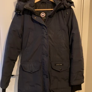 Canada Goose vinterjacka dam strl S  - Jackan är i fint använt skick. Den är dessvärre för liten nu så den har hängt i garderoben ett tag. Kemtvätt rekommenderas därav priset. Köpt på NK.  Modellen heter Trillium. Mörkblå