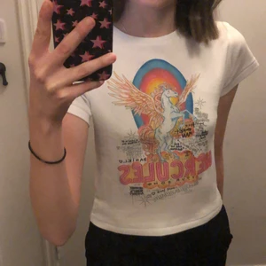 Trendig Hercules topp!💘💘 - En jättefin och populär topp med coolt tryck. Köpt från Realisation Par, deras ”hercules baby tee”. Jättefin verkligen, köptes för ca 600-700 kr💕 knappt använd då den ej är min stil! Skriv vid intresse✨