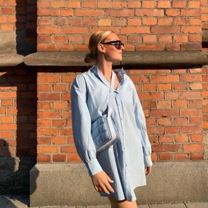 Skjortklänning - Oversized skjortklänning i ljusblå färg! Jättefin och luftig. Snyggt att ha med strumpbyxor. Storlek 36