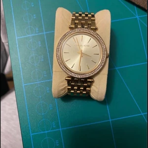 Michael Kors klocka - Dam klocka i modellen Darci. MK-3191.  Michael Kors Klocka som ny. I princip orörd klocka har för det mesta legat i klocklådan. Enstaka repa, inget defekt. Klockan är i guld.  Obs; Box medföljer ej därav priset.  Kan tänka mig gå ner i pris vid snabb affär! 