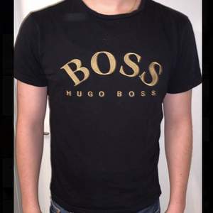 Hugo Boss T-shirt storlek S för men. Svart med guld text, enkel och riktigt fin tröja! Tröjan är givetvis äkta, hör av dig om du vill se fler bilder! (Inga skador på tröjan precis som ny!)