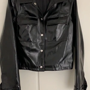 Kort jacka i skinnimitation  - Kort jacka från Nelly i fejkskinn. Sparsamt använd. 