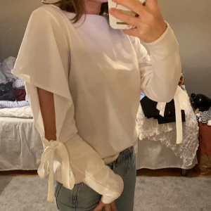 Blus från zara - 🎀SKRIV ETT PRIS!!🎀En cool blus med knytdetalj på armarna tillsammans med en snygg volang effekt! Denna blusen är i ett mycket bra skick och har knappt använts:) -köparen står för frakten!