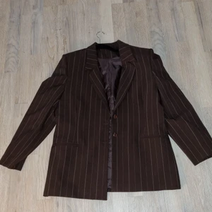 Kavaj med axelvadd  - Mörkbrun kavaj med ljusa ränder och bruna knappar. (Frakt får kunden stå för själv om det så önskas)