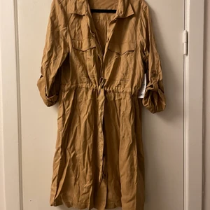 Brun oanvänd klänning  - Oanvänd brun klänning från Gina. Lapp kvar! Frakt tillkommer. Storlek 38