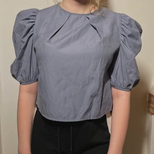 Ljusblå topp - söt ljusblå topp med puffärmar, storlek M Lite kortare i modellen. 