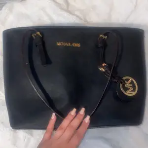 En Svart Michael Kors väska som jag antar är fake. Den är väldigt rymlig och den är i fint skick, inte använd så mycket.