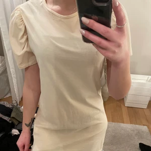 Klänning stl M men funkar som S  - Puffärmar, klänning. Ser gulare ut på bild men den är beige! 