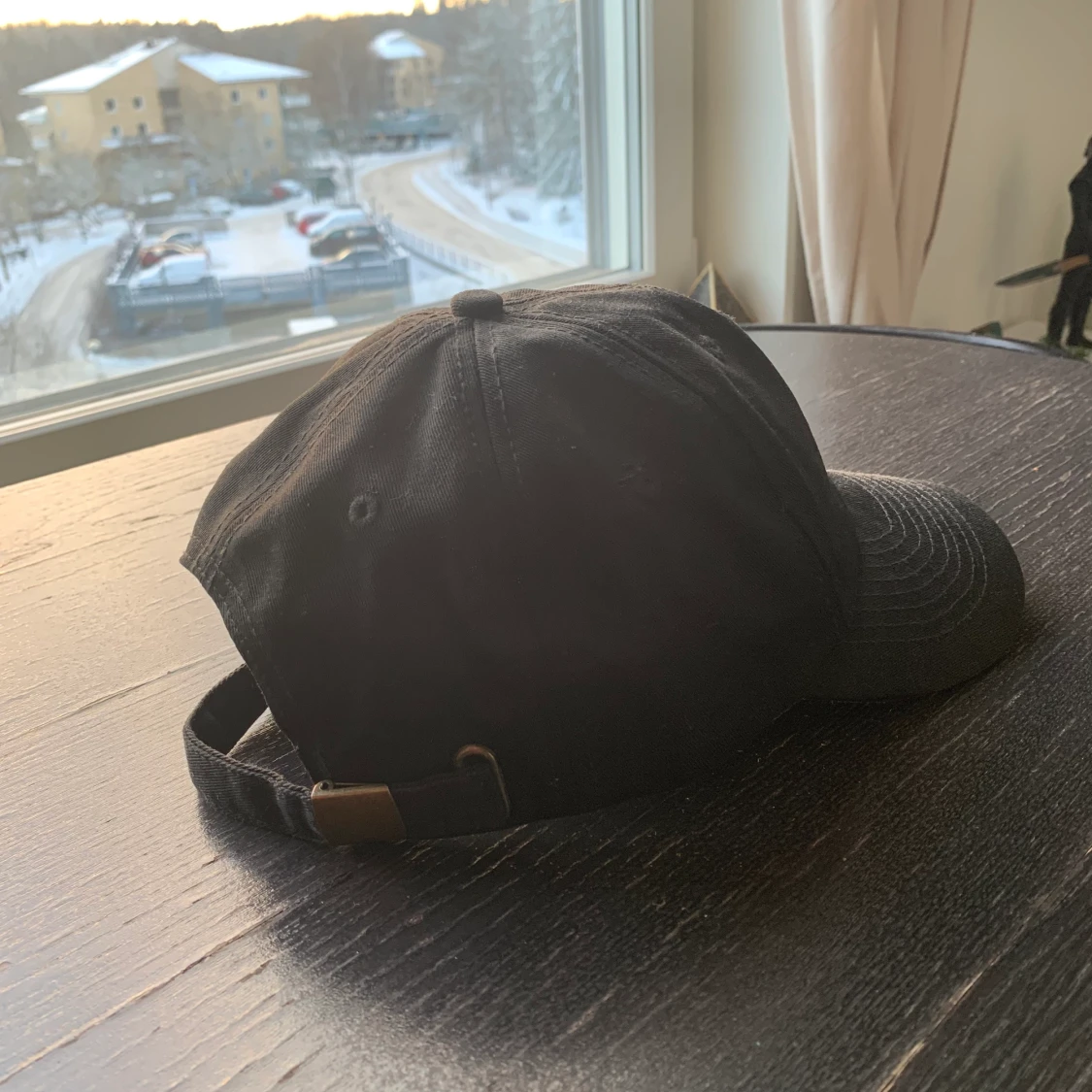 Svart keps med en lite figur - 90