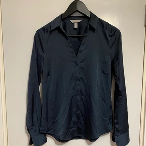 H&M skjorta i storlek S - Fin marinblå skjorta i storlek S. Fin siden tyg, glansig. Mycket bra skick.