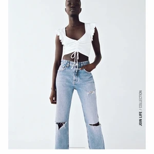 Vit crop top, linne med volanger i storlek M - (Lånad bild från Zaras hemsida) Säljer mitt vita crop top linne från zara i storlek M. Säljer den pga att den sitter lite löst på mig då jag köpte fel storlek. Använd ett fåtal gånger. Säljer även den i svart. Den är köpt för 89kr. Start bud 60kr+frakt