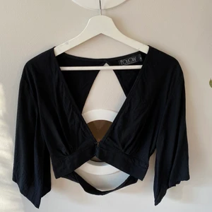 Svart croptop - Svart croptop med djup urringning och var rygg. Storlek S