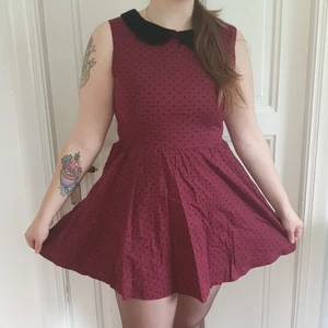 Vinröd, prickig Hellbunny klänning i storlek Large - Vinröd prick rockabillyklänning med svart krage och vackert hjärtformade på ryggen.