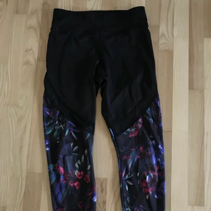 Blommiga träningstights  - Väldigt stretchiga tights. Svarta och blommiga med en nät/mesh-remsa på låret. Skriv för fler bilder! 