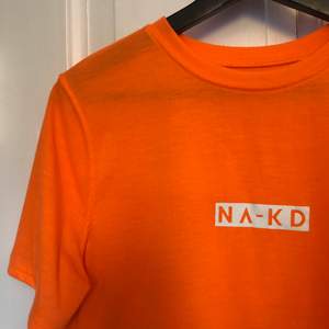 Cool orange t-shirt i boxmodell från NAKD, storlek medium. Mycket fint skick. Snygg till sommaren. Köparen står för frakt!