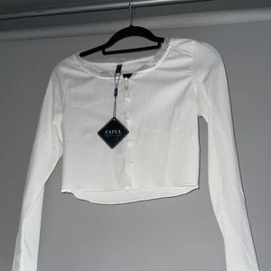 Ribbad tröja med knappar - Tröja med knappar, ribbad. Köpt på ZAFUL. Storlek M men skulle säga att den passar en S. 50kr eller buda om de är fler som är intresserade!! Skriv om du vill ha fler bilder eller har frågor🌸