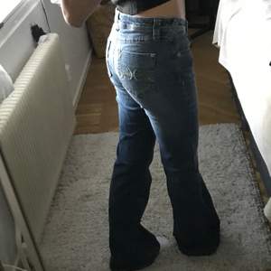 Säljer dessa snygga trendiga 2000s lowwaist jeans!! Skitsnygg passform, har skitcool design på bakfickorna och söta detaljer 🤩 🤩💗 är 165 cm  :)