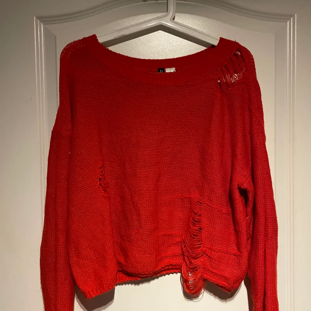 Röd stickad tröja med slitningar från H&M. Köparen står själv för frakten . Stickat.