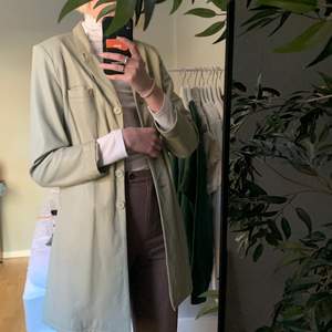 Cool grå-beige läderkavaj i lite längre modell, går ungefär till låret! Storlek 40 men skulle säga att den är mer S/M size! Köpt secondhand, är i härligt vintage skick!