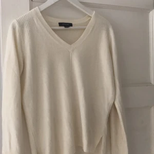 Vit tröja. - En vit mysig tröja köpt på primark. Denna är använd några gånger, men i fint skick. Tröjan har knappar på sidorna och en v-skärning.köpare betalar frakt 