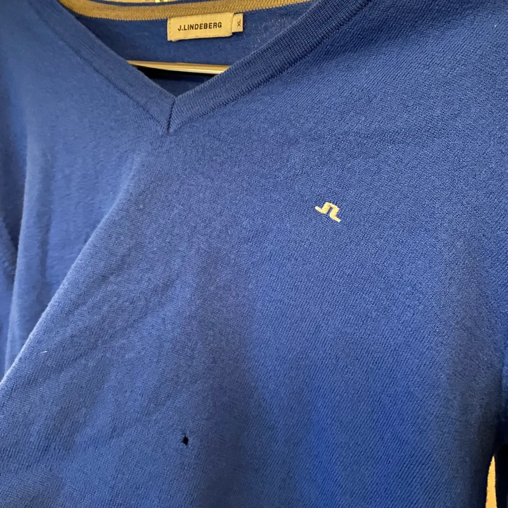 Jätte fin mörkblå stickad tröja från j Lindeberg. Färgen ser ni på bild 2&3. Ett litet litet hål i mitten av tröjan dock annars jätte fint skick! Står storlek XL men är en S. Stickat.