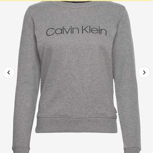 Grå sweater från Calvin Klein! Använd ett fåtal gånger och passar så snyggt tillsammans med en skjorta! Klassisk enkel och användbar i många tillfällen. Storlek M, svart logga över bröstet och grå till färgen!