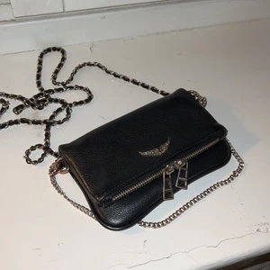 Zadig väska - Hej, jag säljer nu min zadig väska i modellen rock nano. De är den lilla modellen. Har använt i ca 1 år men väldigt sparsamt som ni ser. Har kvar kvitto och dustbag och alla tags. Köpt på NK. Lägg bud eller skriv privat! Kan frakta om köparen står för frakten eller mötas i centrala Stockholm.