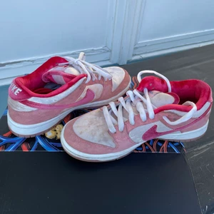 Nike Sb Dunks low - Strangelove dunks Strlk 40,5 (herr) 25,5 cm. Sitter likt en 38/39 i damstorlek. Röda skosnören medföljer. Väldigt fina men framförallt bekväma skor som skiljer sig från andra då de är gjorda av velour. Visar gärna fler bilder, genom sulorna syns paljetter, en fin detalj! Skorna är använda men fortfarande i fint skick🫀 OBS kan tyvärr inte vara 100% säker på äkthet då jag köpt de i andra hand 