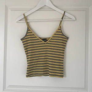 Randig crop top - Gult croppat linne med svart/vita ränder från Gina Tricot. Materialet är ribbat och tunt. Använd ett fåtal gånger🐝💛