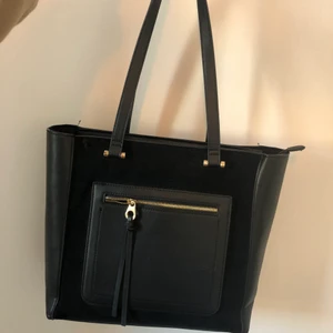 Väska med guld detaljer  - Väska från glitter med guld detaljer och dragkedja. Stor väska får plats med mycket, endast ett stort fack inuti. Fint skick. Inga defekter. 