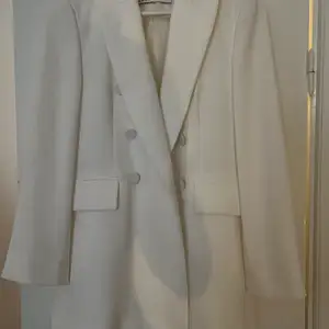 En superfin vit kostym från Zara, kavajen är i storlek s och byxorna xs. Jag är 168 cm och byxorna sitter ”långt” modellen på byxorna är bootcut. 