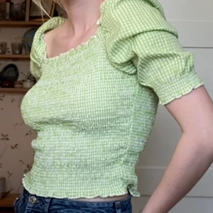 Grön topp/blus - Grönrutig topp från Monki köpt förra våren 🍃💚 Har typ bara använt den 2 ggr för tycker inte den är riktigt min stil. Den sitter jättebra på mig som är en 36a och funkar även jättebra utan bh under. Kolla gärna mina andra annonser för paketpris! 🥰