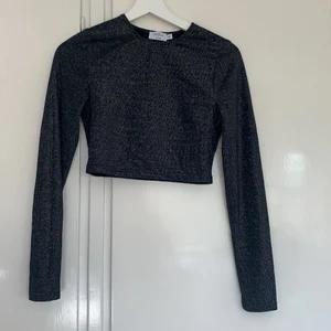 Glittrig långärmad topp - Så fin passar bra till fest! Köpt för länge sen så tror inte den finns kvar. Den är croppad!