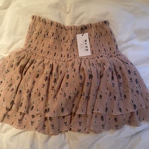 Blommig rosa kjol  - Säljer denna supersöta kjol från nakd då den va för stor på mig som brukar ha xs-s. Kjolen är i storlek 36 men skulle säga att den är ganska stor. Den är oanvänd och lappen finns kvar så den är i nyskick🌸 Jag köpte den för 400kr förra sommaren 