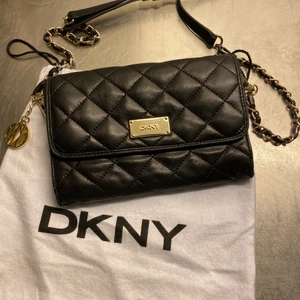 DKNY svart quiltad väska - DKNY-väska i svart mjukt skinn. Använd ett fåtal gånger. Inköpt på Zalando. Kan ha kvittot kvar. Kommer med dustbag.