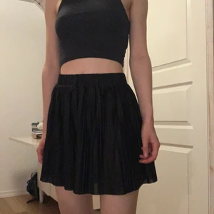 Plisserade shorts - Plisserade svarta shorts från monki. Svala och sköna inför sommaren! Shortsen är pösiga med vida ben och ser därför ut som en kjol. Använd ett fåtal gånger. Shortsen är i XXS men stora i storleken så passar XS, nog även S (beror på hur pass låg eller högmidjade man vill ha dem). Jag har vikt in shortsen på ett ställe i midjan och sytt in med några stygn då de var för stora för mig som högmidjade shorts. Stygnen går lätt att ta bort!