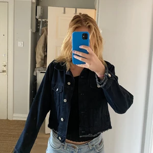 Mörkblå jeansjacka - Mörkblå kort/croppad jeansjacka från topshop! Jättebra skick och kvalitet med snygga detaljer! Jag är ca 175 och på mig slutar den precis över rumpan och sitter bra i ärmarna. Köparen står för frakten!