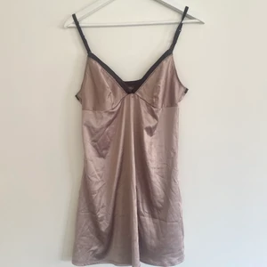 Slipklänning  - Jättefin slipklänning i skimmrigt och stretchat tyg. Strl L står på lappen, skulle säga att de egentligen är en M men skulle passa S också. Beige/cappuccino färgad med bruna detaljer. Justerbara band. 
