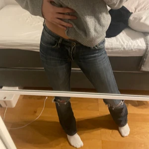 Lågmidjade bootcut jeans - Säljer dessa skitsnygga trendiga lågmidjade jeansen med hål på knäna från crocker! Storlek 27/33 och passar mig som är 170 cm lång och en s/m! 