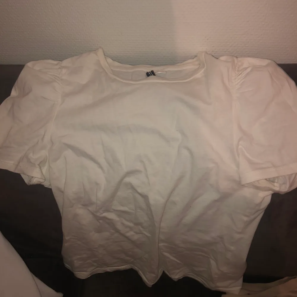En vit t-shirt med puff ärm ifrån hm i str xs, den sitter inte jätte tajt så om du har S kommer den passa dig. Köparen står för frak.. T-shirts.
