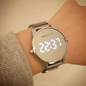 En klocka med spegelskärm - En fin klocka som sitter bekvämt på handleden! Armbandet sätts fat med magnet som man kan se på den andra bilden. Skärmen på klockan är en liten spegel. När man trycker på knappen på höger sida kan man se tiden. Tiden ser man cirka 5s sen försvinner den. Men de är bara att trycka på sidan för att se den i gen. Är lite repor på glaset man knappt så att de syns. Köpt för cirka ett halv år sen, men knappt använd. Fungerar som ny!