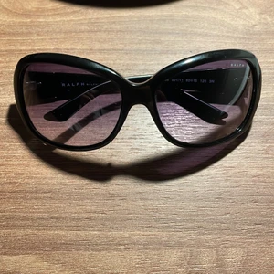 Ralph Lauren Solglasögon  - Väldigt fina äkta solglasögon från Ralph Lauren. Perfelt för varma sommardagar! Men kommer tyvärr inte till användning längre. Läder fodral, putsduk och informationslapp ingår i priset. Väldigt bra skick! Köpta för 1100 kr. Se bilder! (Frakt medkommer utifrån priset)