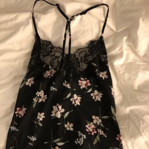 Svart satinlinne  - Svart satinlinne med spets och blommor. Aldrig använt💘