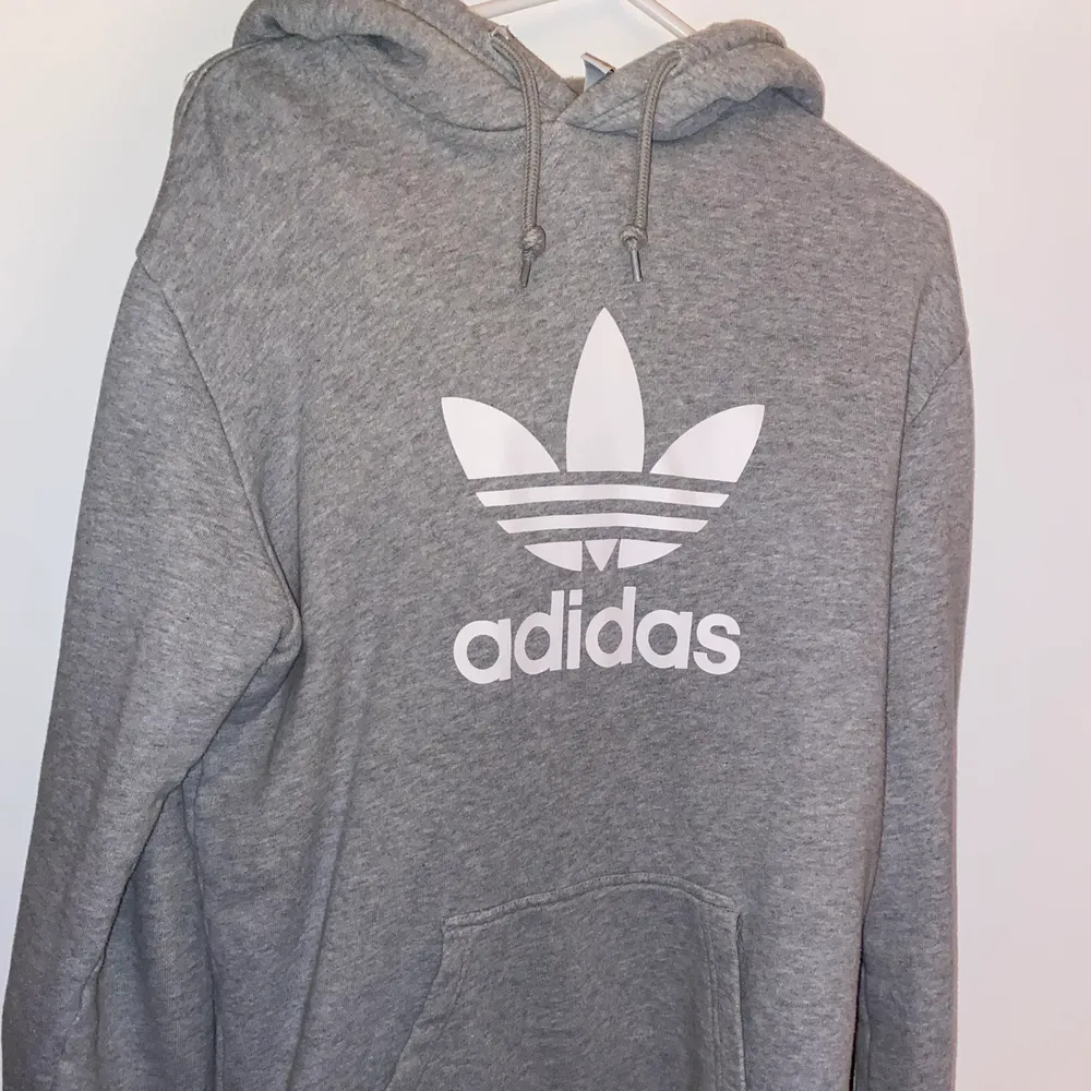 En grå Adidas Orginals Hoodie i storleken SMALL. Det är en vintage stilfixerad hoodie och den sitter som svensk medium då den är amerikansk storlek. Hoodien köptes 2018 i San Fransisco men har ej använt den på över ett år!DM VID INSTRESSE ELLER FRÅGOR <3. Hoodies.