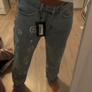 Straight smiley jeans - Asballa jeans med smiley tryck! Helt oanvända. Köpta här men säljer vidare då det var fel storlek. Buda i kommentarerna!☺️☺️