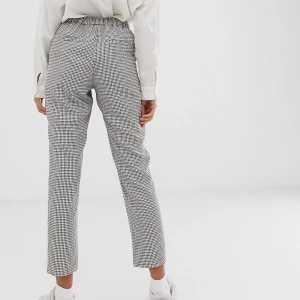 Nya byxor med sidoband/ oanvända/ storlek 42 - Oanvända byxor från Asos i rutigt mönster med sidoband. Nypris 500 kr. Resor i midjan och avsmalnande passform. Storlek 42, men passar även 40. Mjukt vävt tyg. Skriv för fler bilder :) 