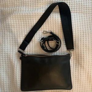 Carin Wester väska - Liten väska från Carin Wester. Två strapa medföljer. Inga slitningar förutom att dragkedjan har skavts lite. Den har ett stort och ett litet fack på insidan. 